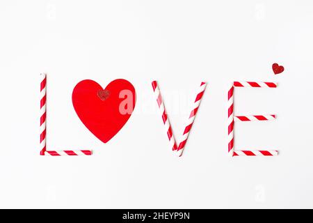 Saint Valentine`s day greeting card, text Love made from striped red and white drinking straws and red heart on white background Stock Photo